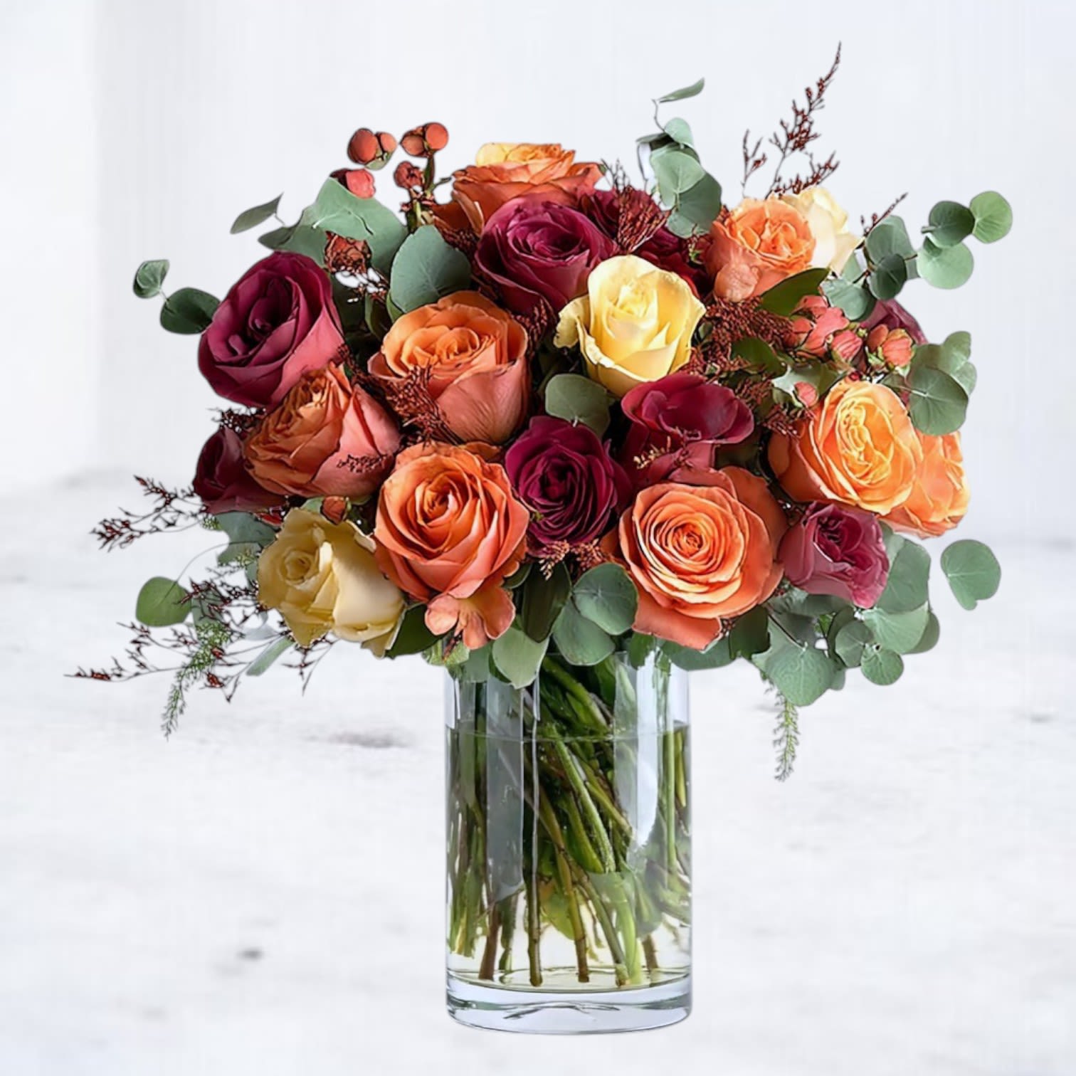 Mixed Roses - The Mixed Roses arrangement features a rich blend of premium roses in warm, complementary hues. Designed with fresh greenery and arranged in a modern glass vase, this bouquet brings a striking yet timeless beauty to any occasion. Whether you're celebrating a birthday, sending gratitude, or sharing a thoughtful gesture, these roses make it effortlessly meaningful.  Available in three sizes to suit any occasion:  Standard: 12 premium roses Deluxe: 18 premium roses Premium: 24 premium roses  Substitution Disclaimer: Rose colors may vary slightly based on availability, but the overall style and palette will always be preserved.