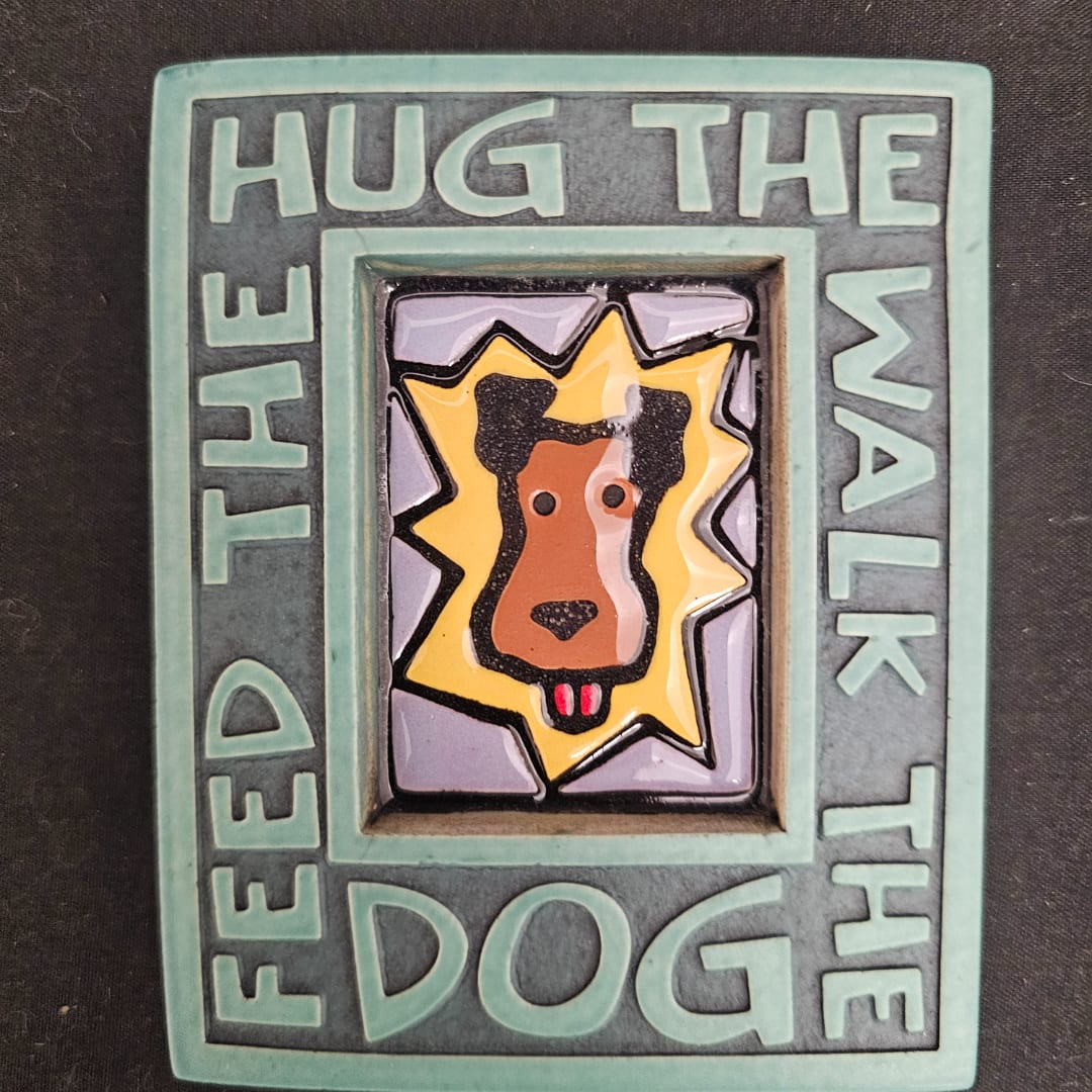 Decorative plaque with a dog face and the words "Feed the Dog"