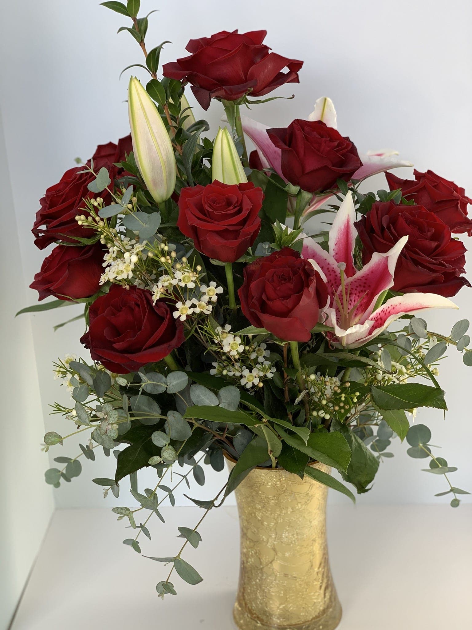 Red roses and pink lilies in a gold vase