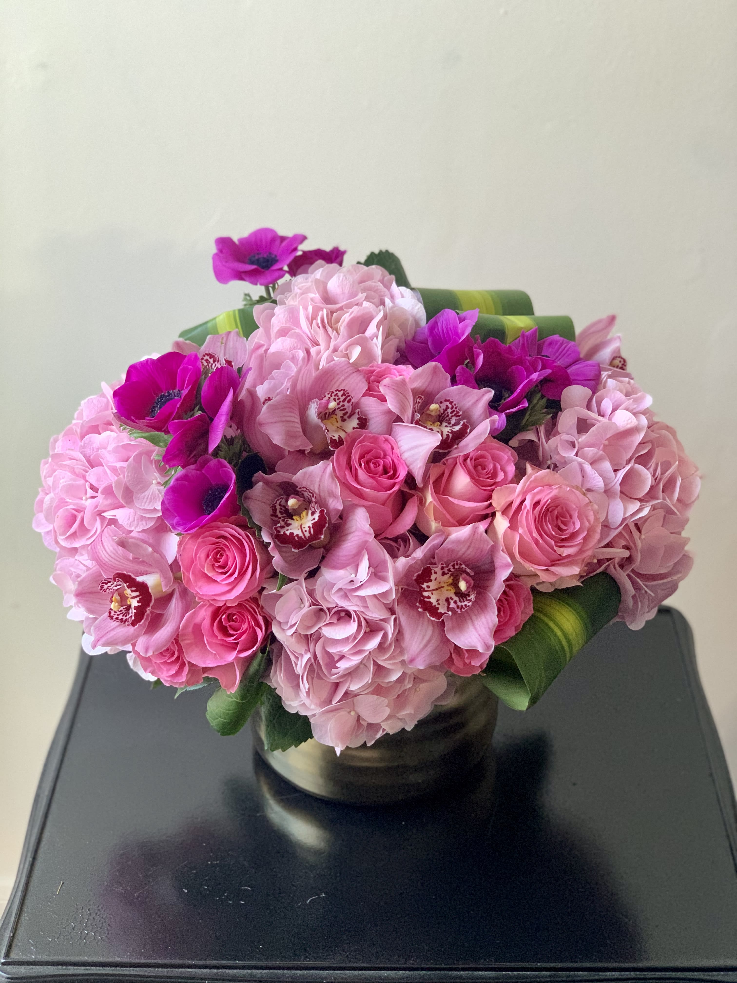 Pink bouquet of roses, hydrangeas, and orchids in a vase