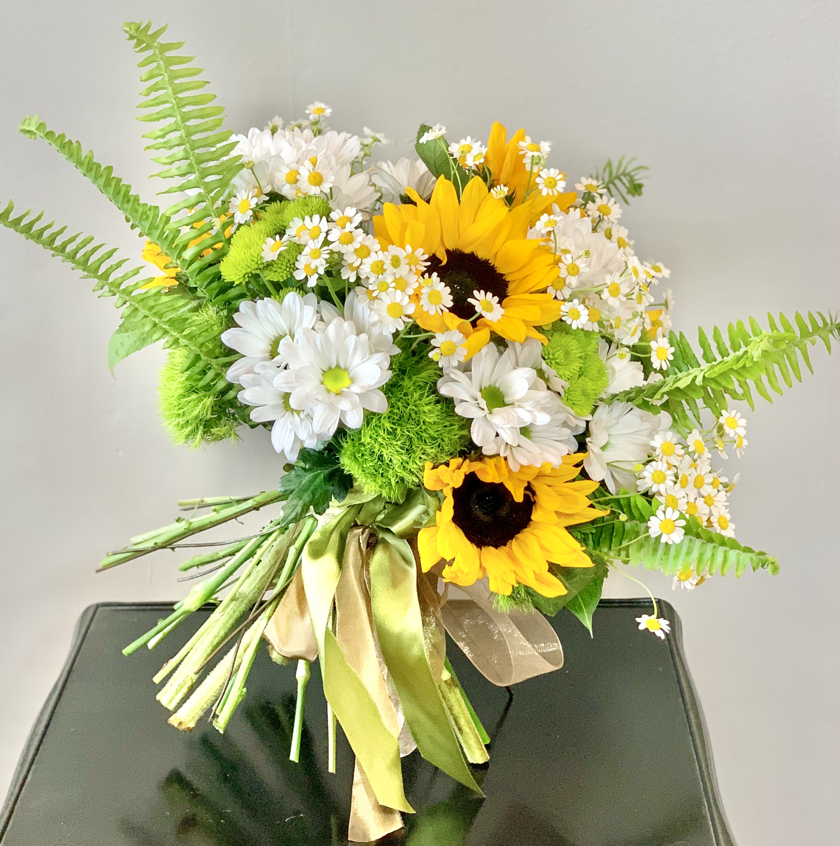Bouquet of sunflowers and white daisies with green fern accents
