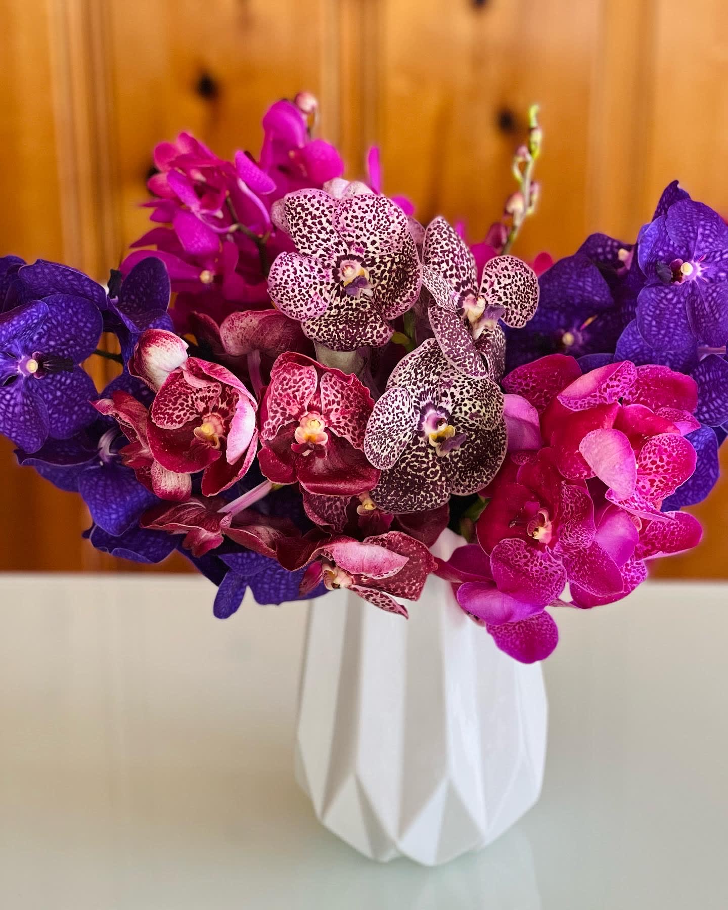 Bouquet of purple and pink orchids in a white vase