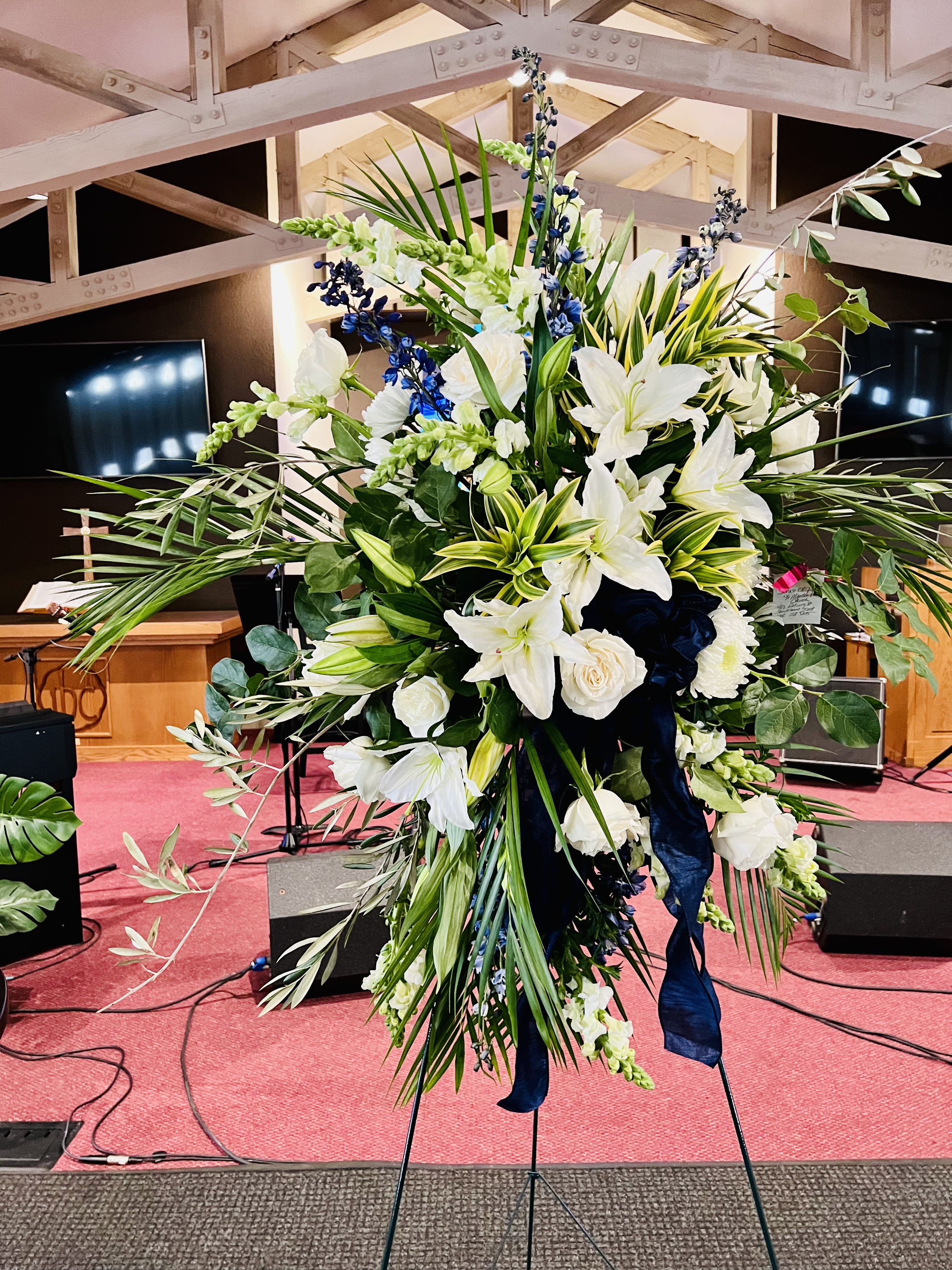 Large white and blue floral standing arrangement on an easel