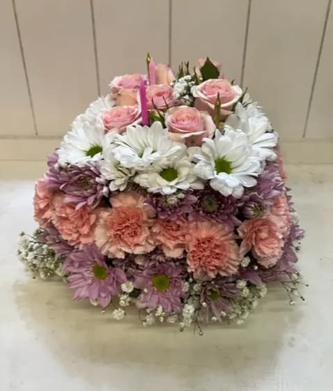 Pink roses and white daisies arranged in a square floral display