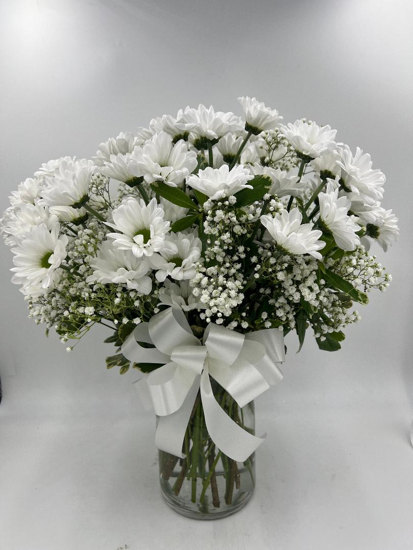 White daisy bouquet in a glass vase with a white ribbon