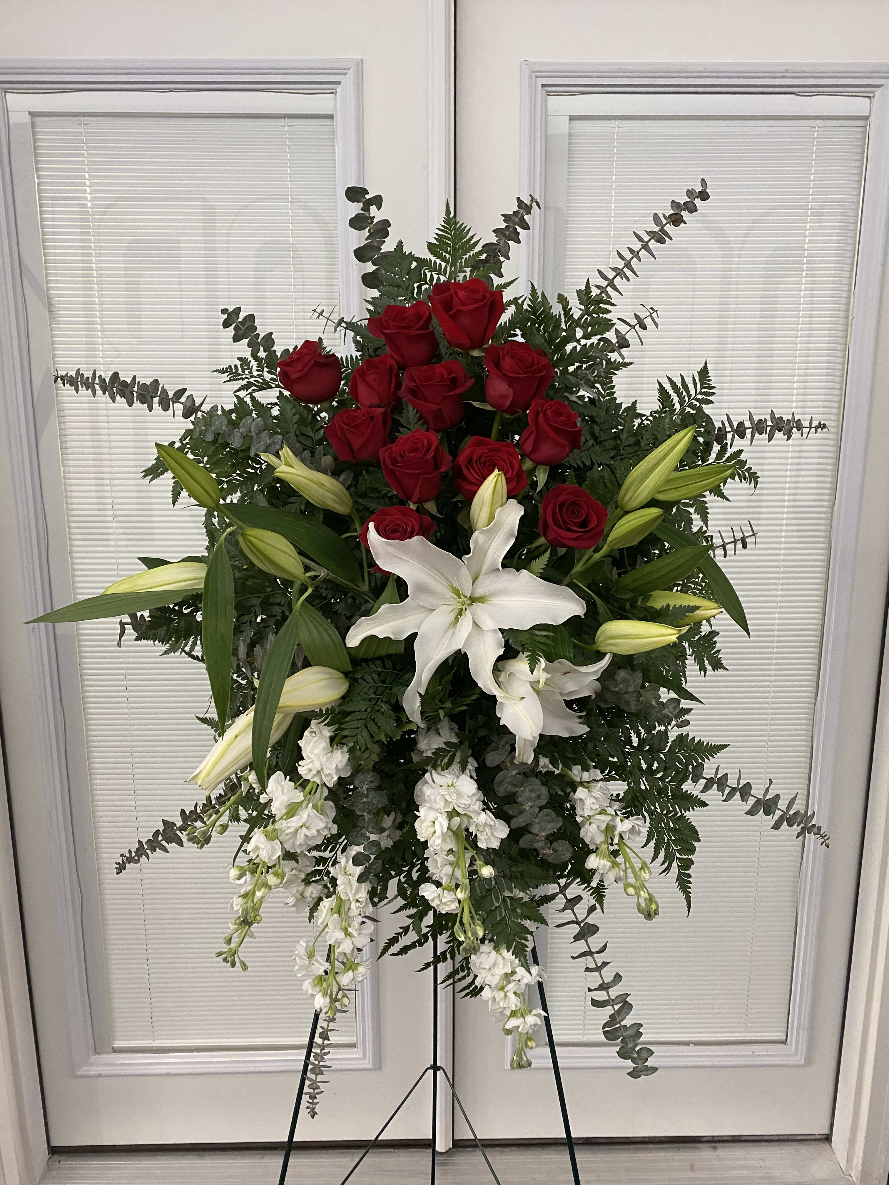 Standing floral spray with red roses, white lilies, and white blooms