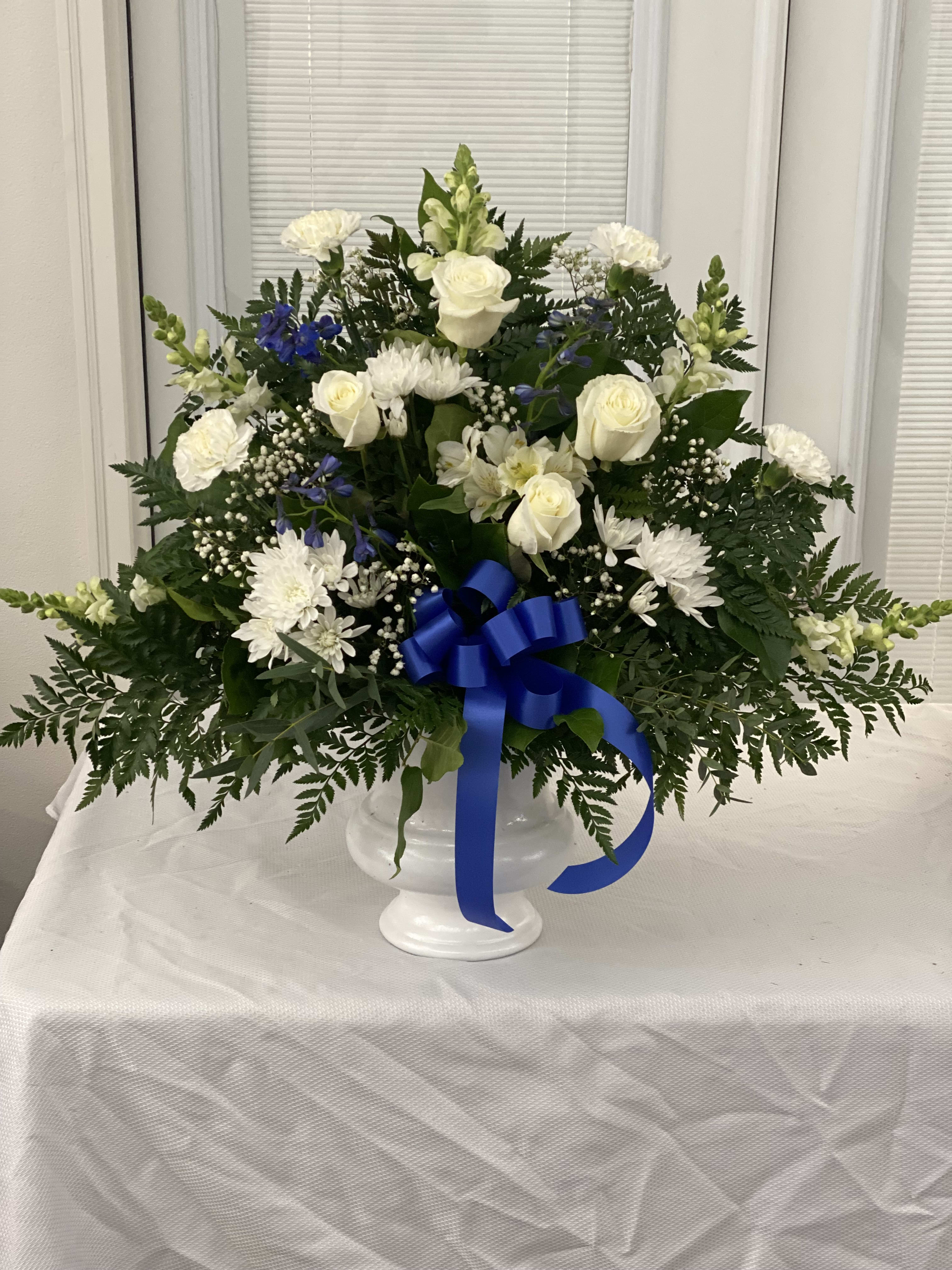 Heartfelt Sympathies Blue &amp; White Mache - Both simple and undeniably stunning, this standing basket arrangement is a beautiful way for you to convey your deepest sympathies. Delicately crafted by our expert florists craft this arrangement, it's a touching tribute for family, friends, or business associates to send to the services. Standing basket arrangement of fresh blue and white flowers such as roses, hybrid lilies, snapdragons, delphinium and more Appropriate for family, friends or business associates to send directly to the funeral home Our florists use only the freshest flowers available, so colors and varieties may vary.
