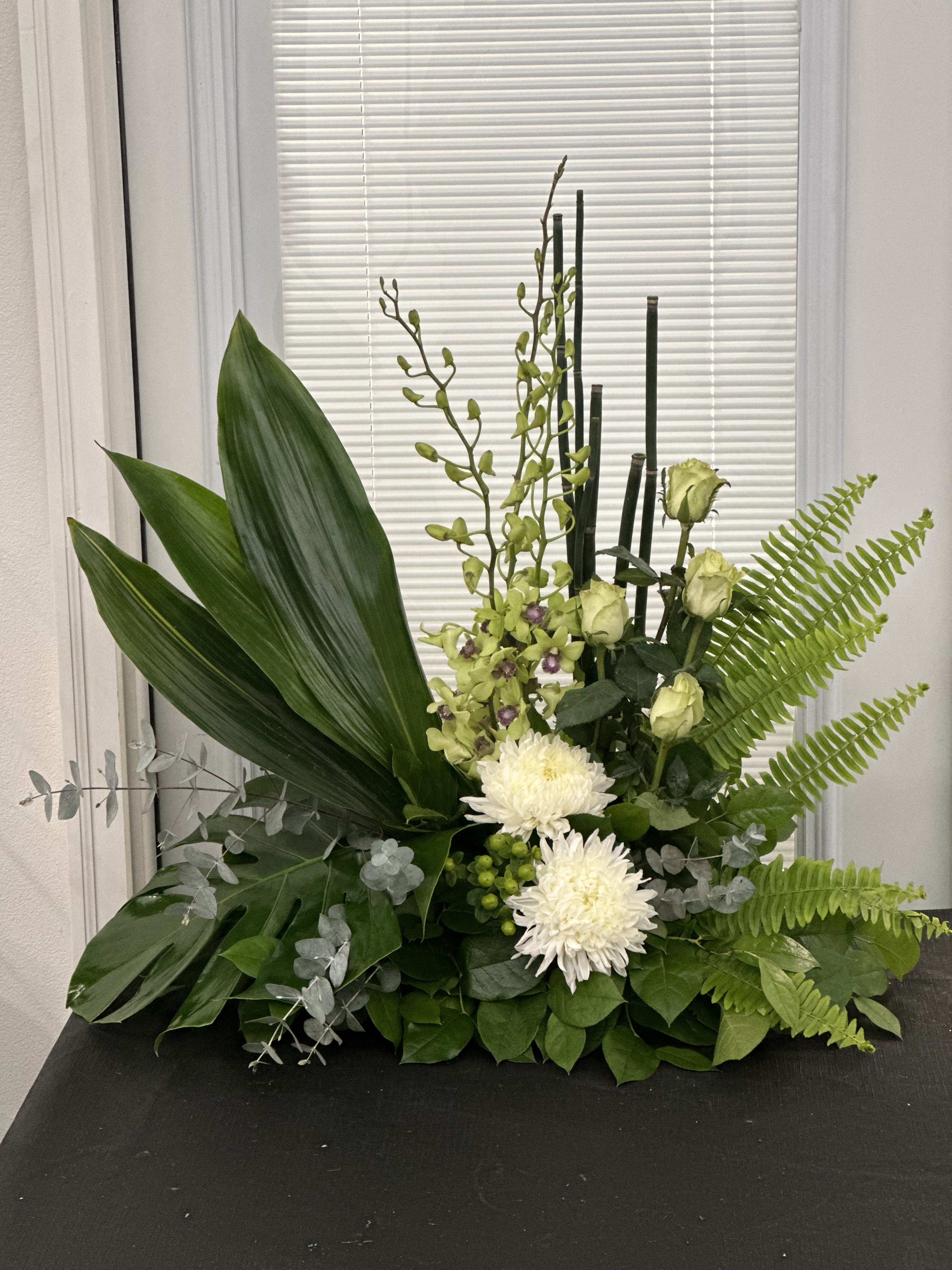 Green floral arrangement with white blooms and tall stems