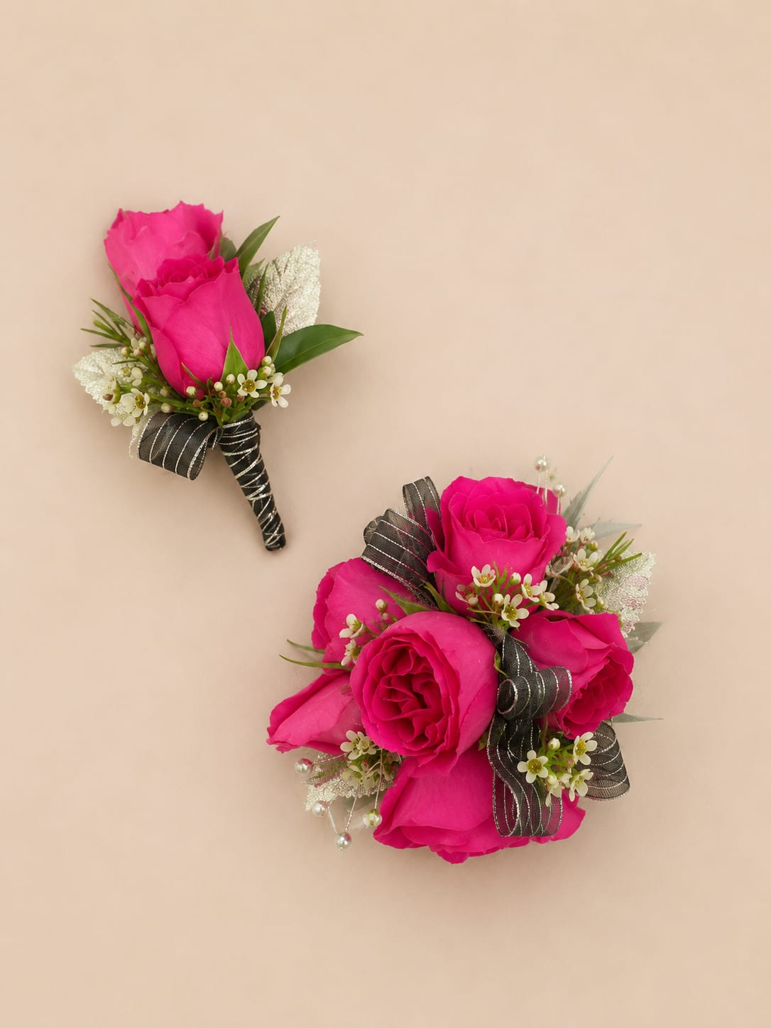 Prom Set Cherry Blush - A hot pink rose boutonniere and matching wrist corsage set that makes a bold, romantic statement for prom, wedding, or any dressy occasion. The tightly layered rose blooms put a bright pink focal point front and center so the person you're honoring will feel celebrated and seen, while black-striped ribbon and silver accents lend a formal, tailored finish that pairs beautifully with a black suit or dark dress.