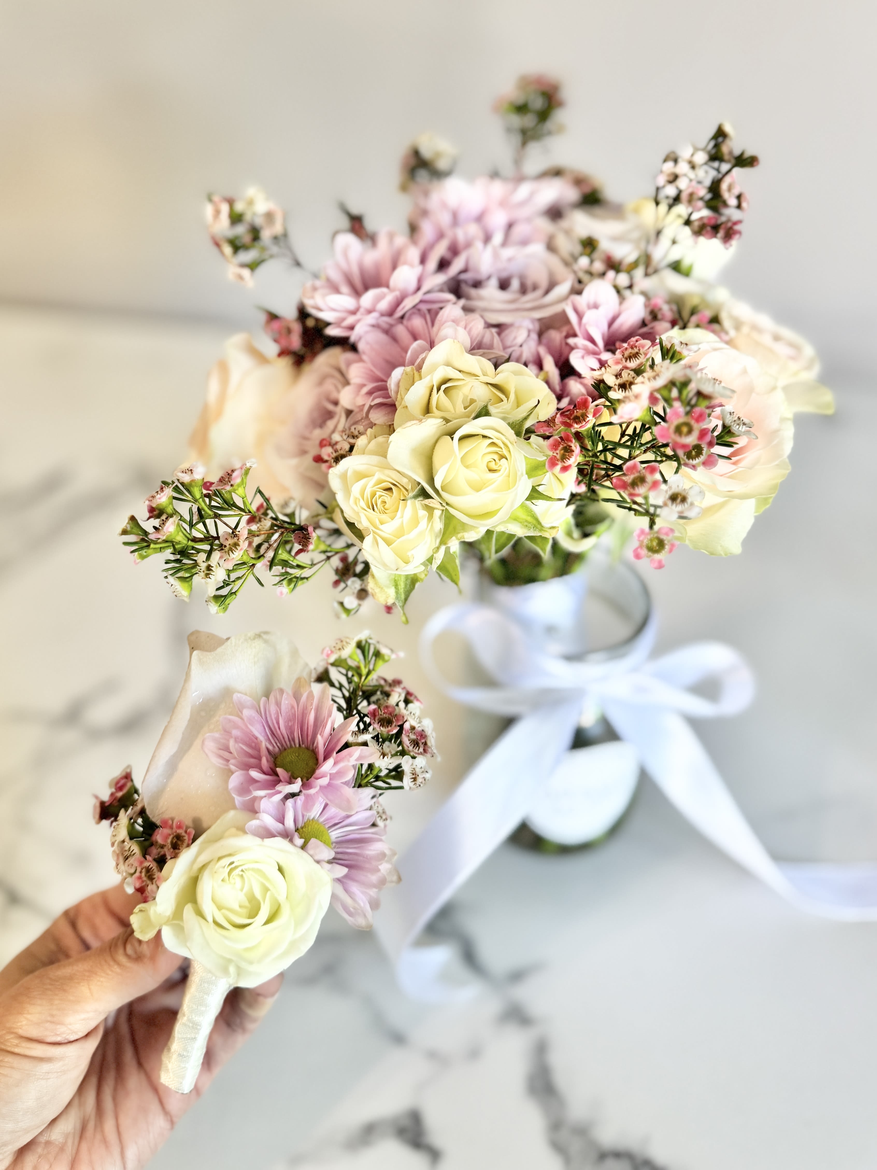 Two small floral bouquets with pale roses and pink daisies