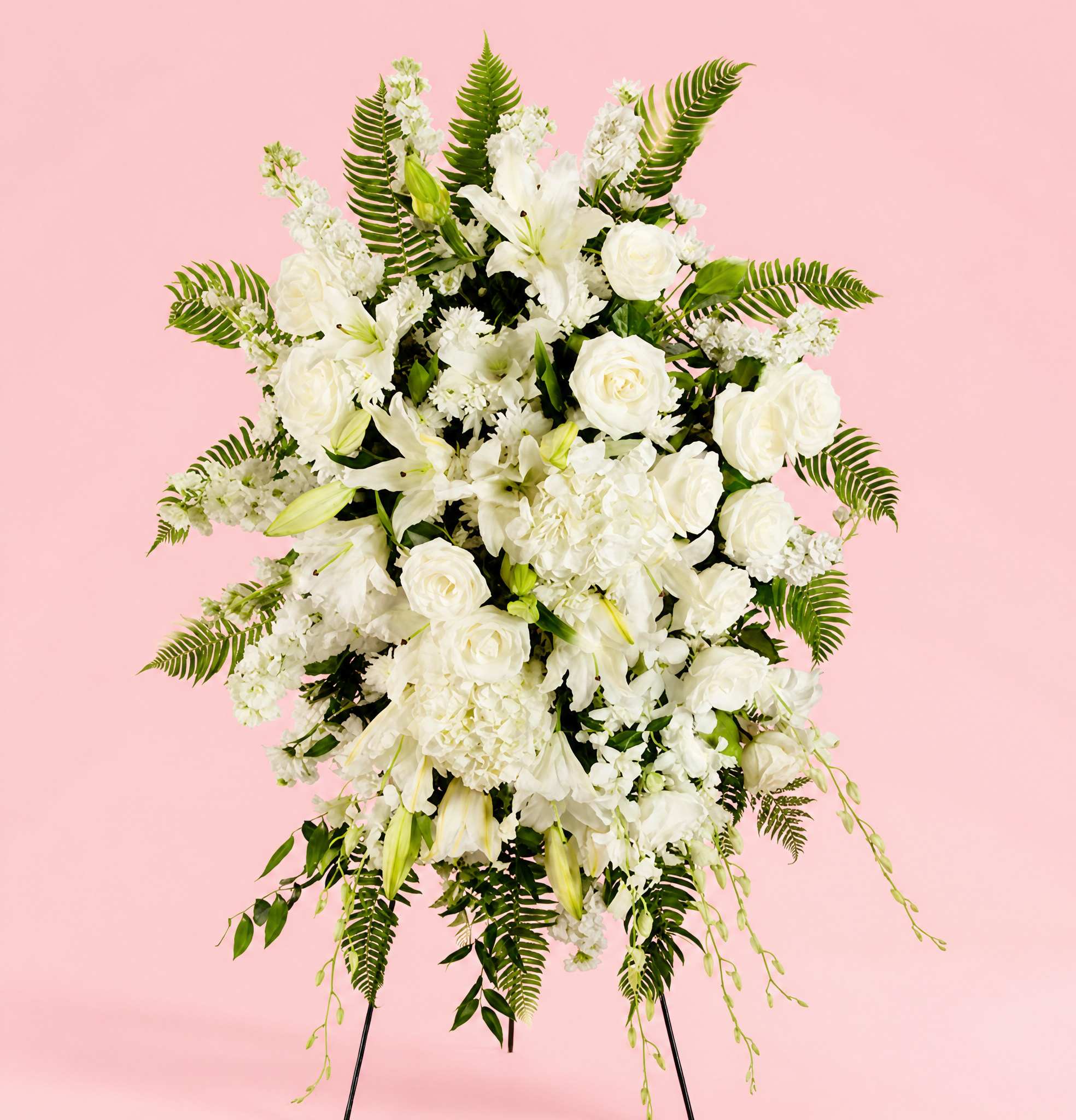 White floral standing spray with roses and lilies on a pink background
