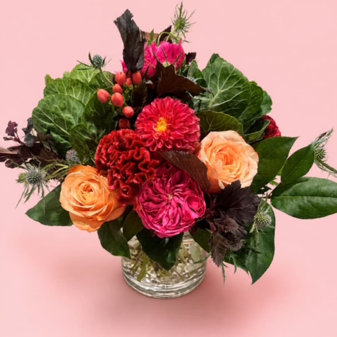 Pink and peach flower arrangement in a clear glass vase