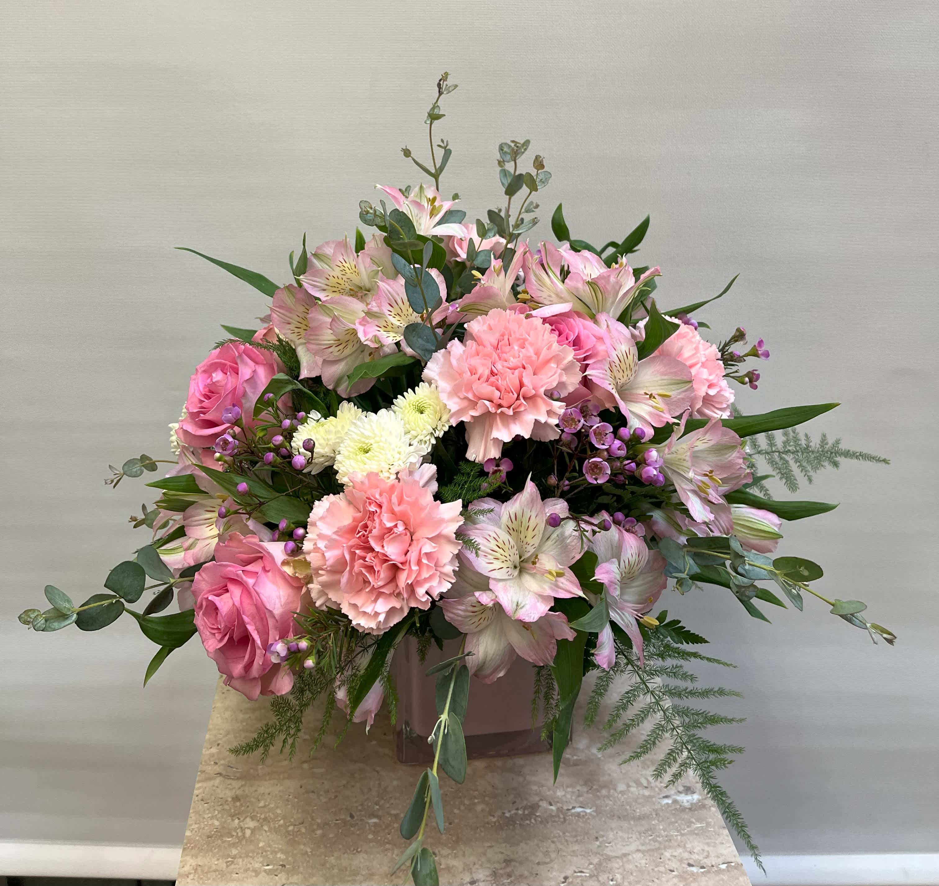 Pink roses and carnations with pale alstroemeria in a vase