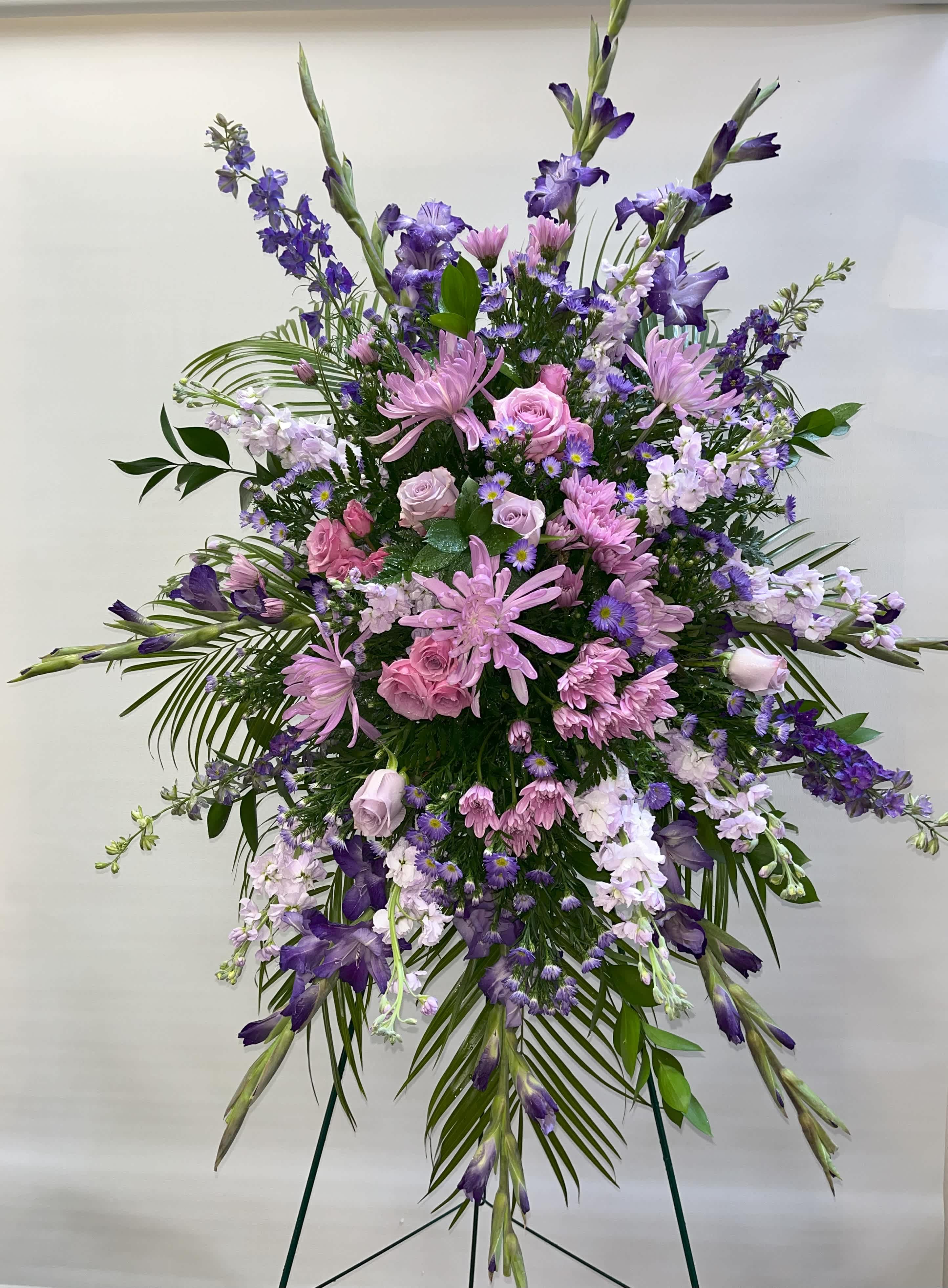 Large standing spray of pink and purple flowers on a metal easel