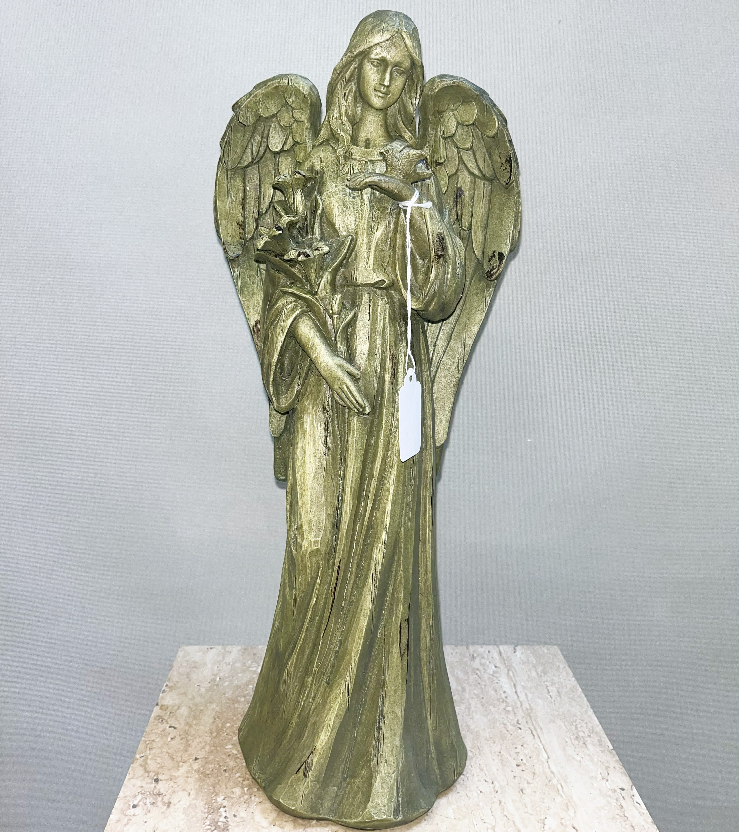 Angel statue holding a bird and flowers