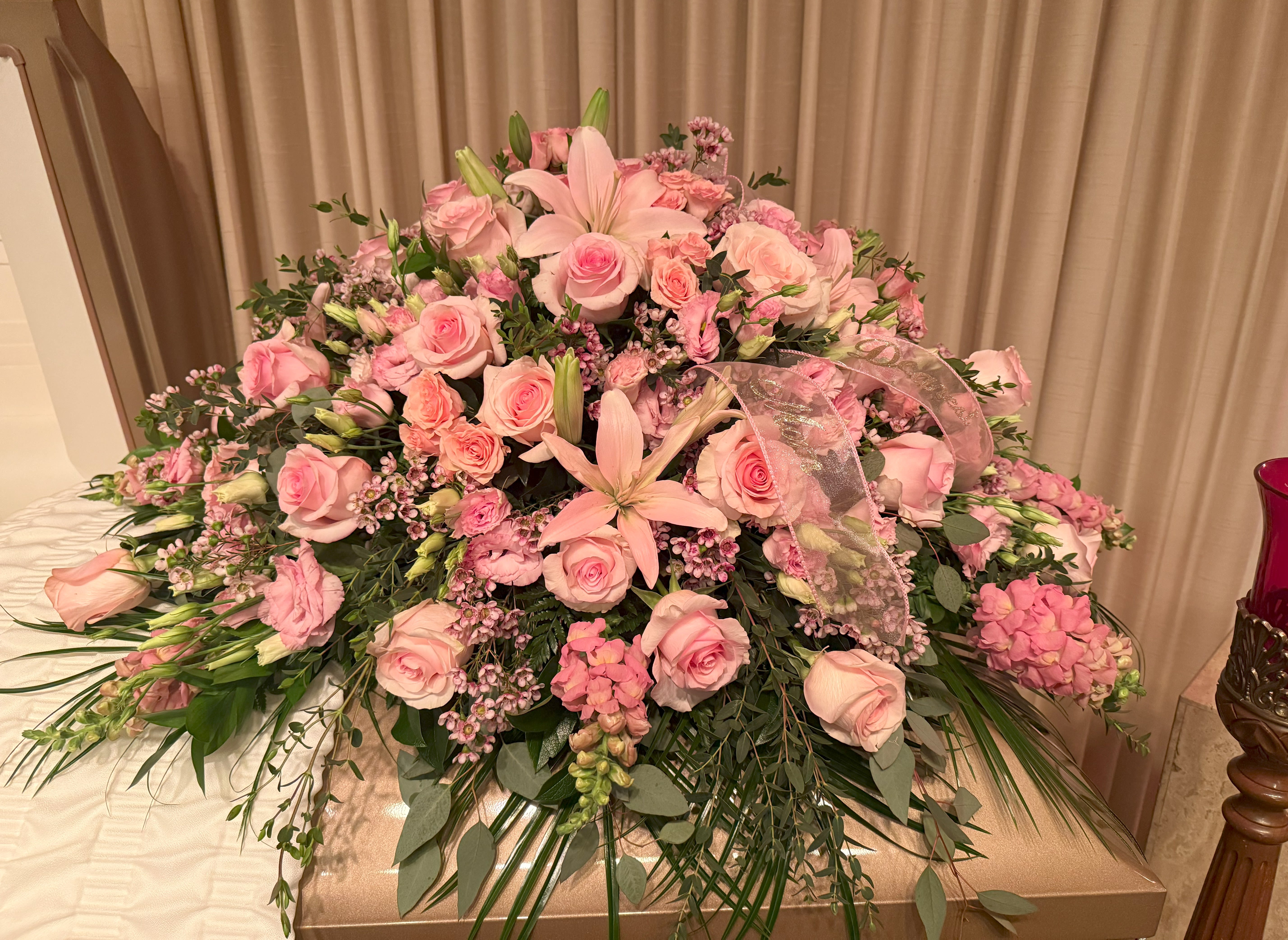 Large pink floral casket spray with roses and lilies