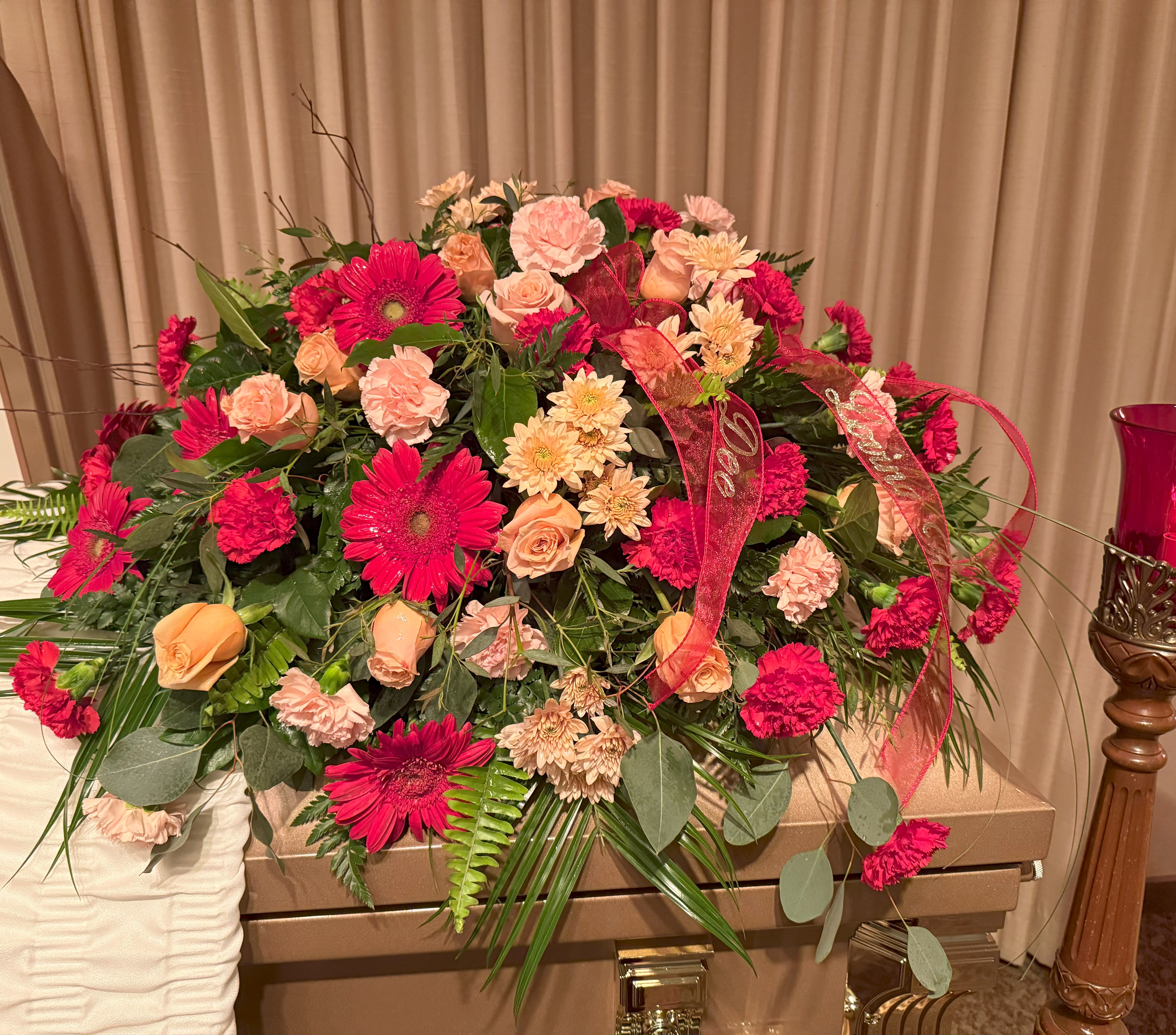 Large casket spray with pink and peach flowers