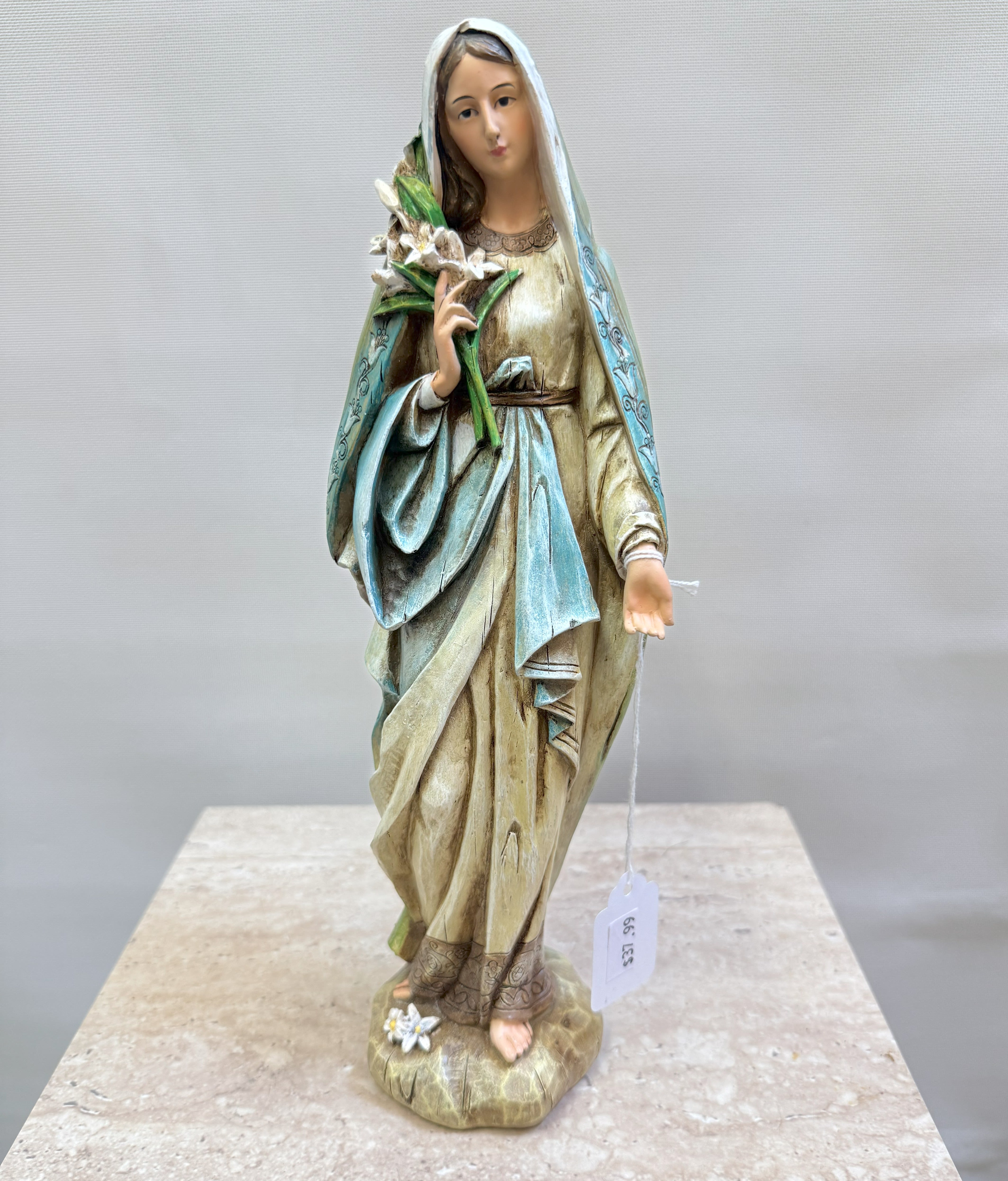 Statue of a veiled woman holding white flowers