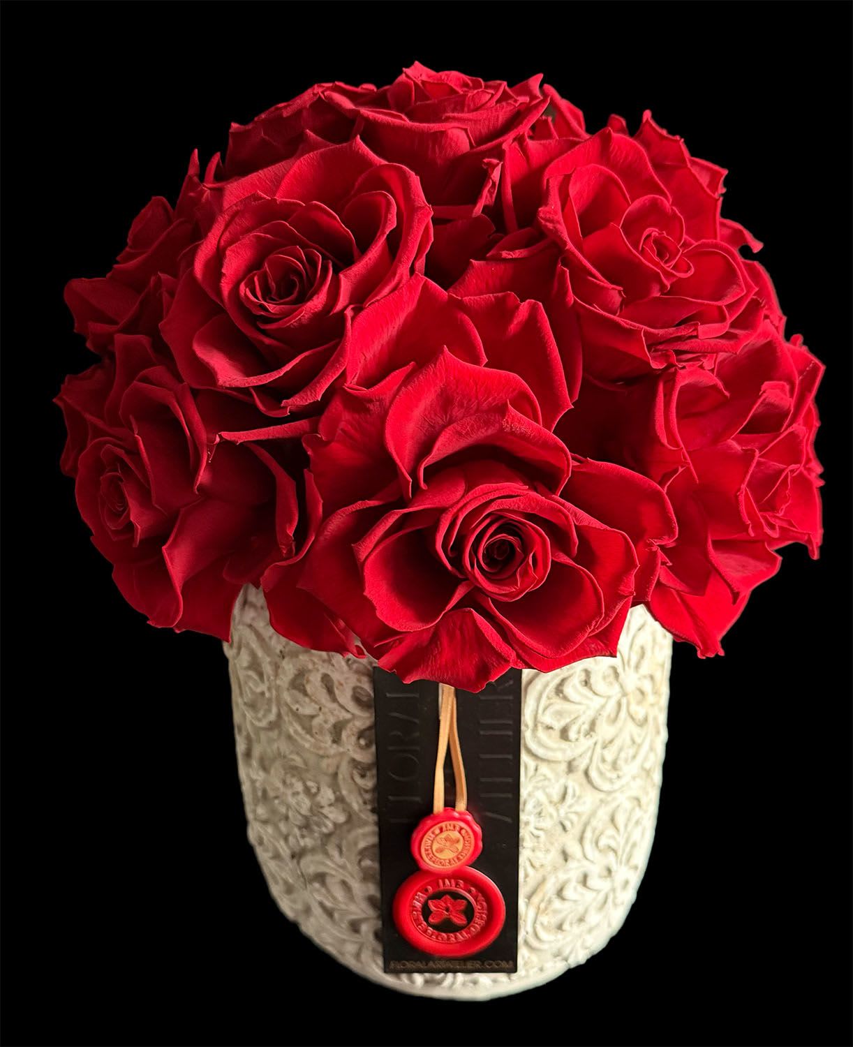 Red roses arranged in a decorative white vase