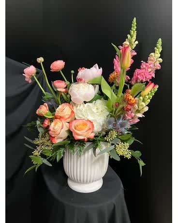 Mixed pink and white floral arrangement in a white vase