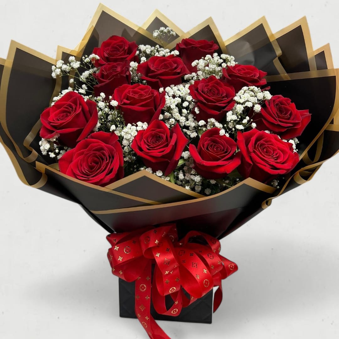 Bouquet of red roses with white baby's breath in black and gold wrapping