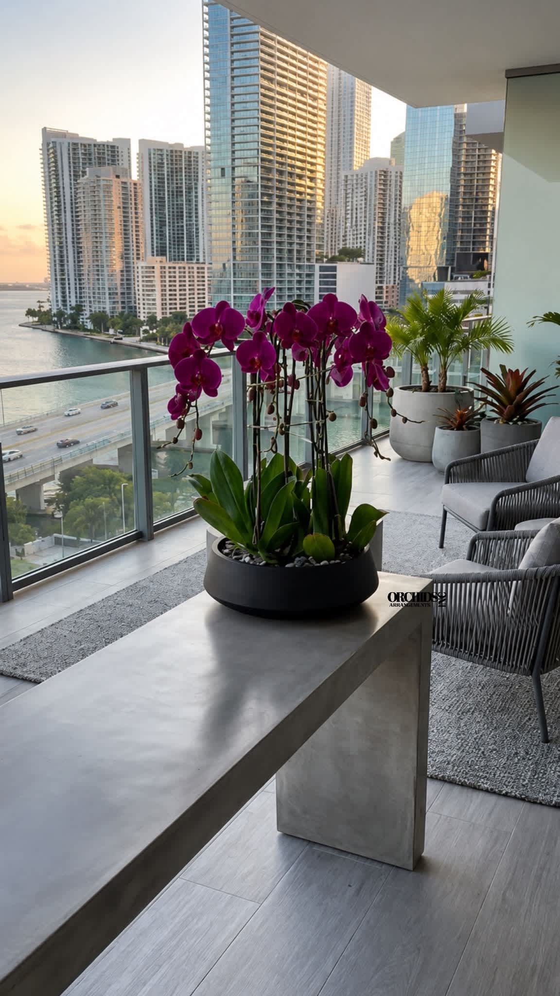 Potted purple orchids in a black planter on a balcony