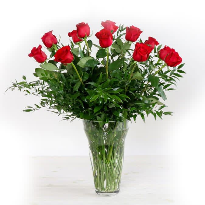 Red roses arranged in a clear glass vase