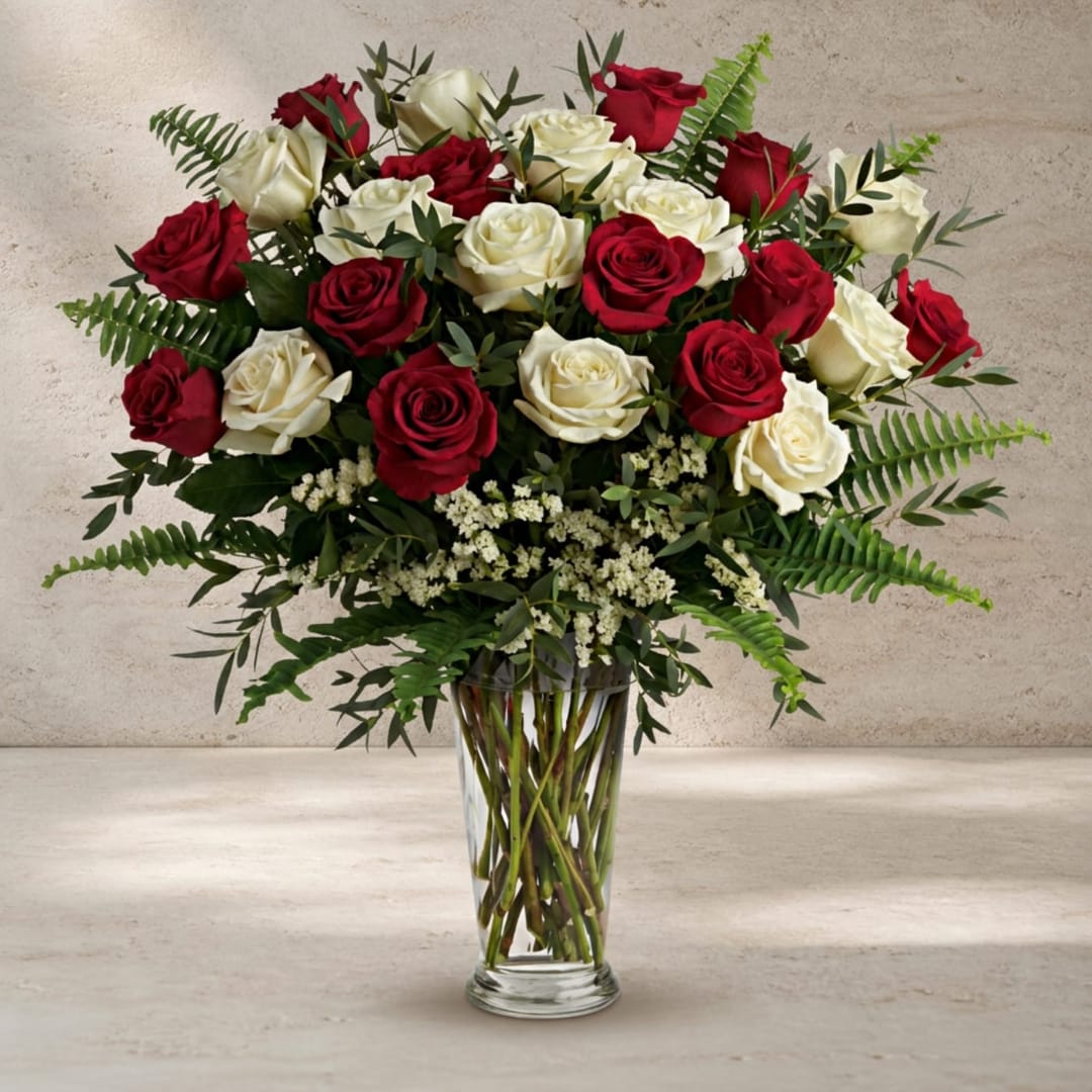 Red and white roses arranged in a clear glass vase