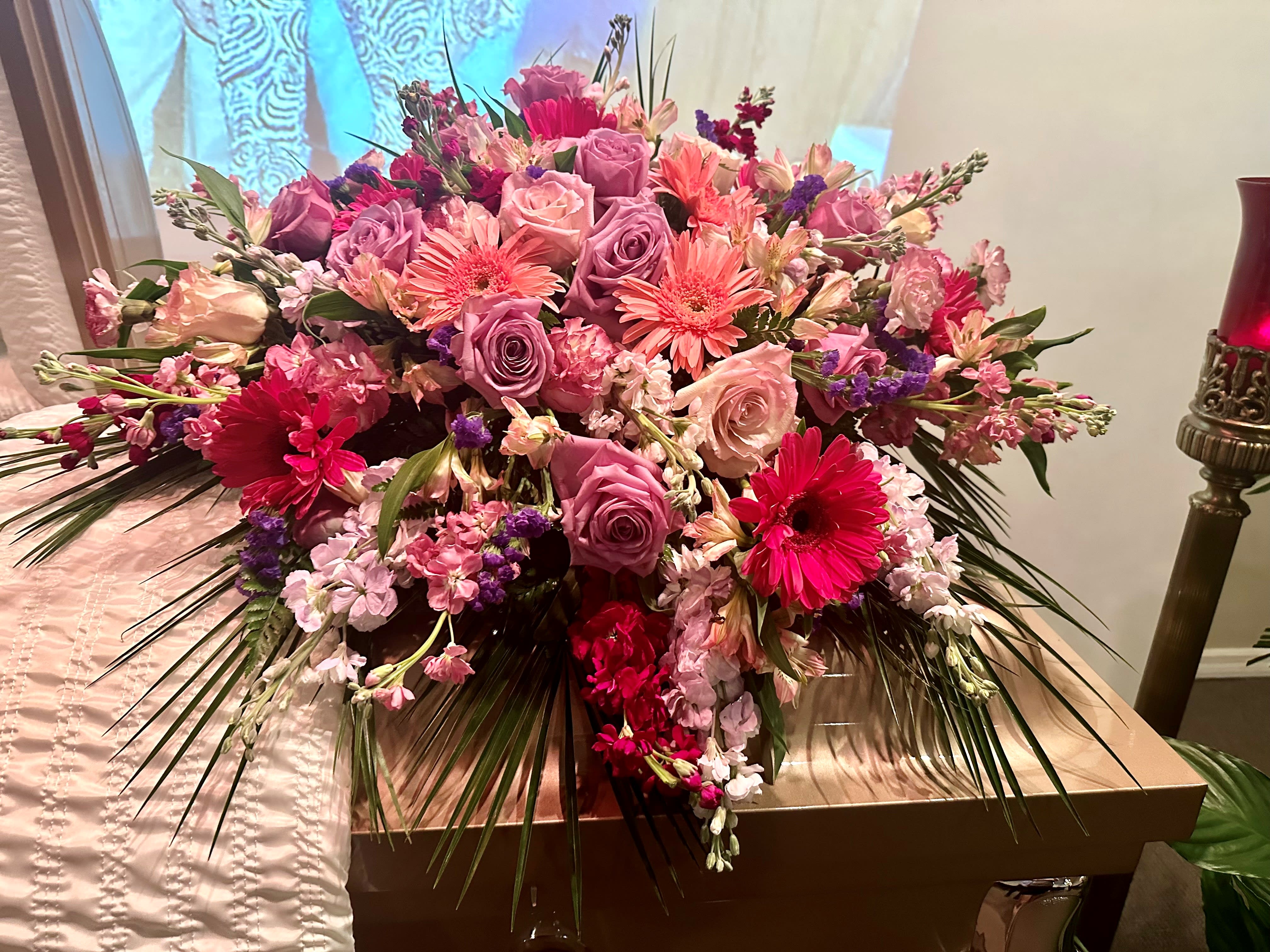 Large pink and purple floral arrangement with roses and gerbera daisies
