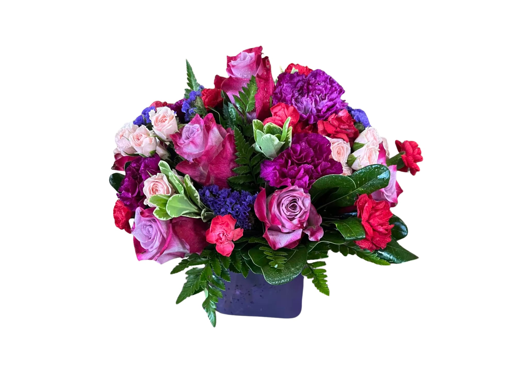 Mixed pink, purple, and red flower arrangement in a purple vase
