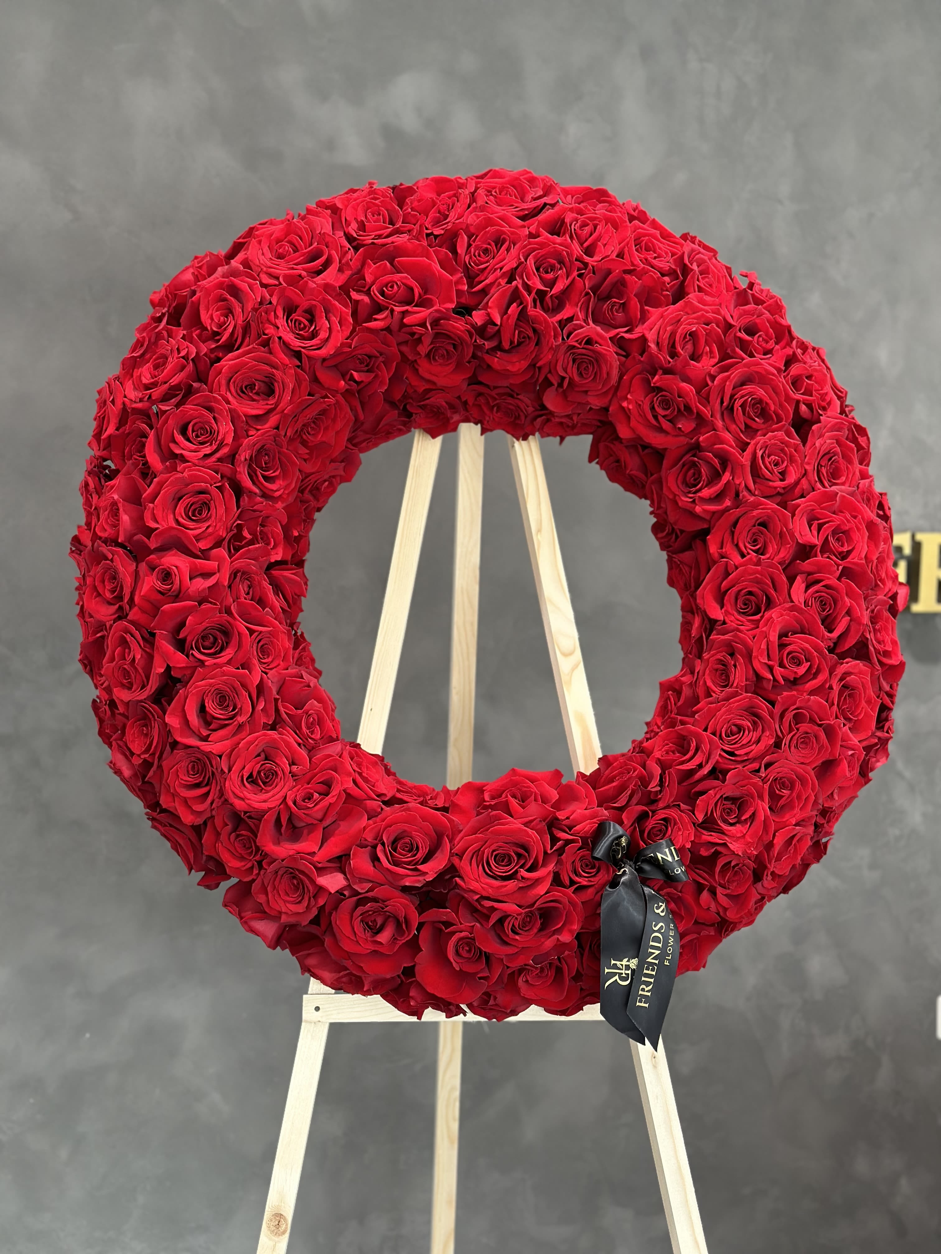 Large red rose wreath on a wooden easel