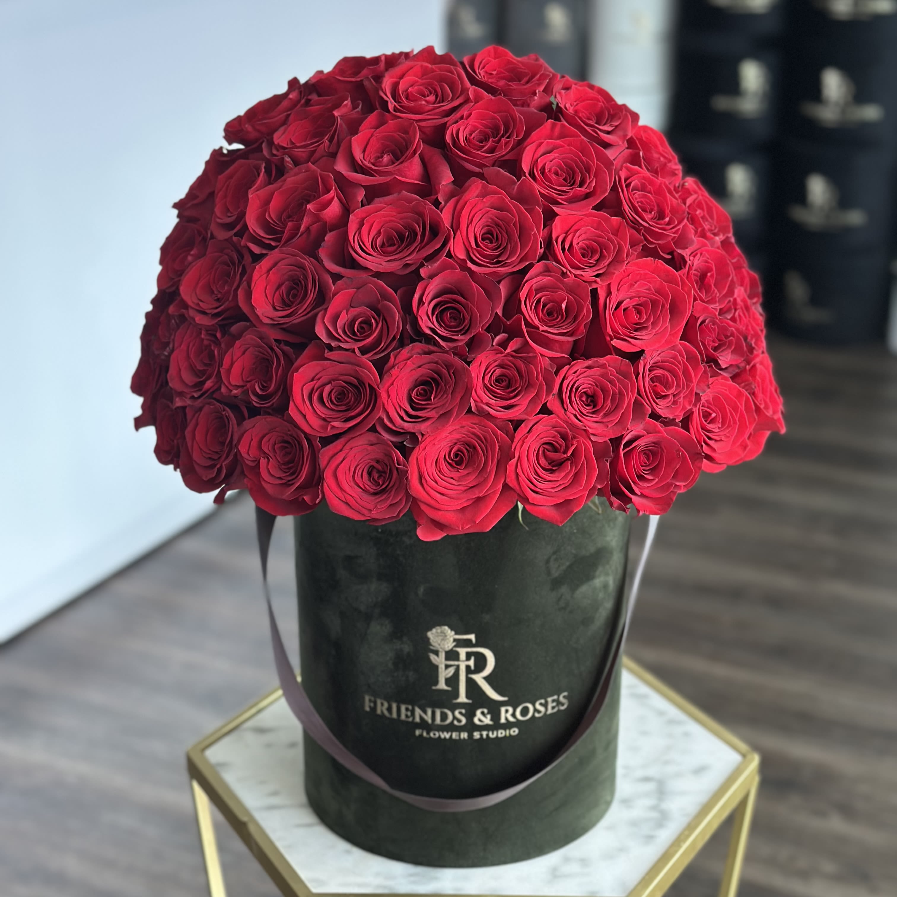 Large bouquet of red roses in a black hatbox