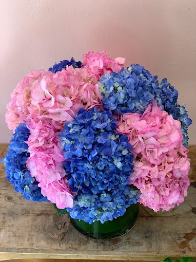 Pink and blue hydrangea bouquet in a green vase