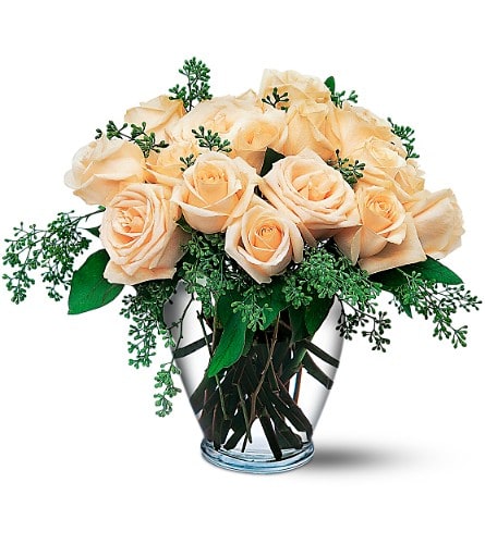 Peach roses arranged in a clear glass vase