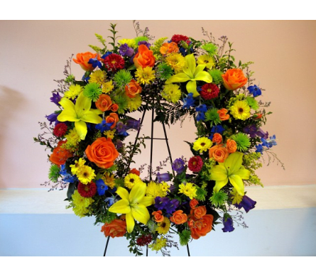 Colorful floral wreath on a stand with roses and lilies
