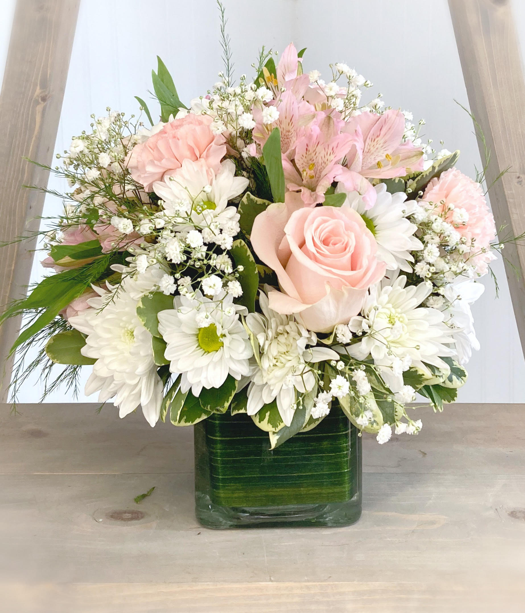 Pink and white mixed bouquet in a square glass vase