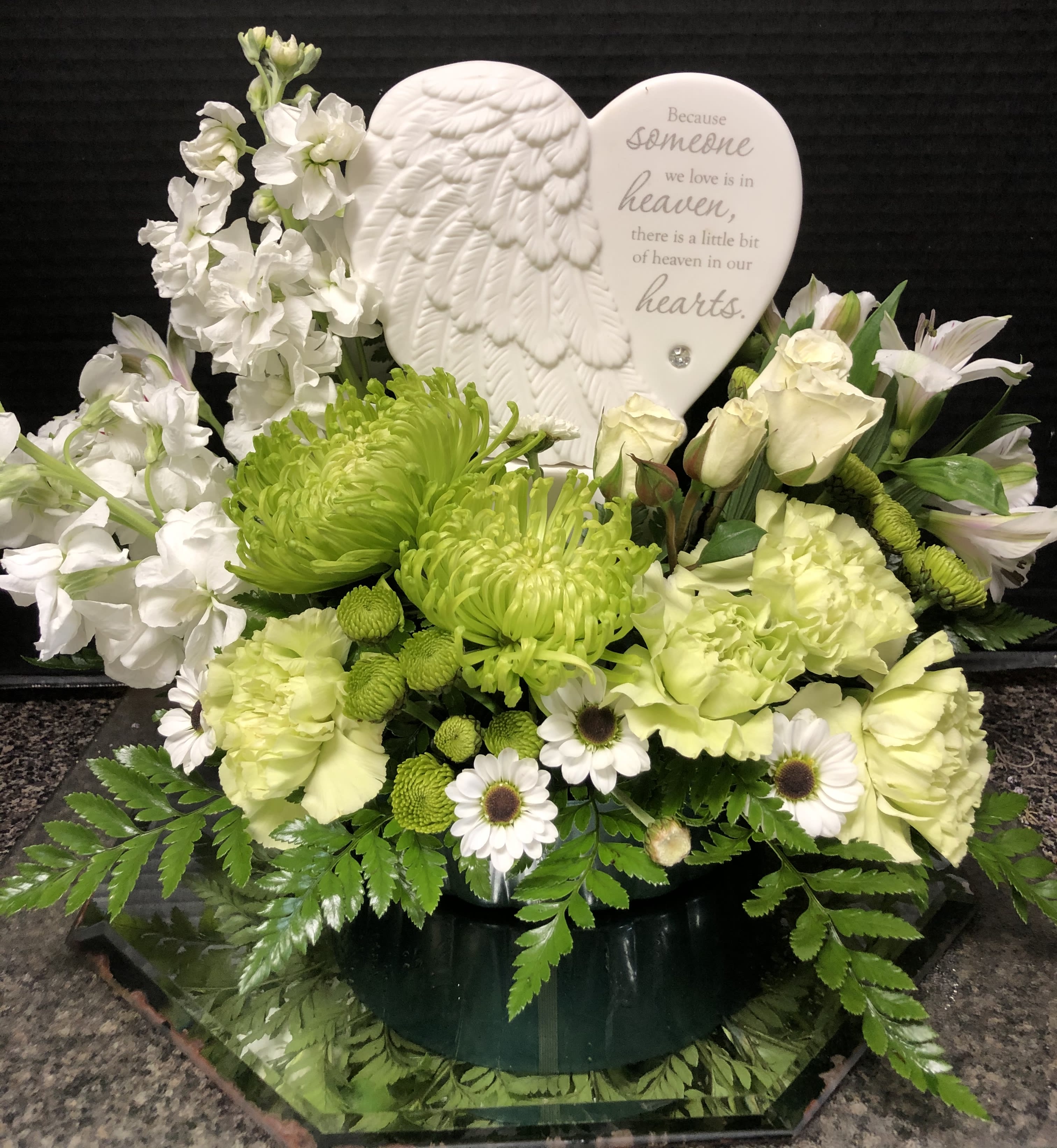 White and green sympathy arrangement with a heart memorial plaque