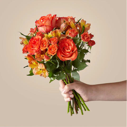 Handheld bouquet of orange roses and alstroemeria