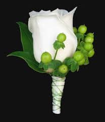 White rose boutonniere with green berries and leaves