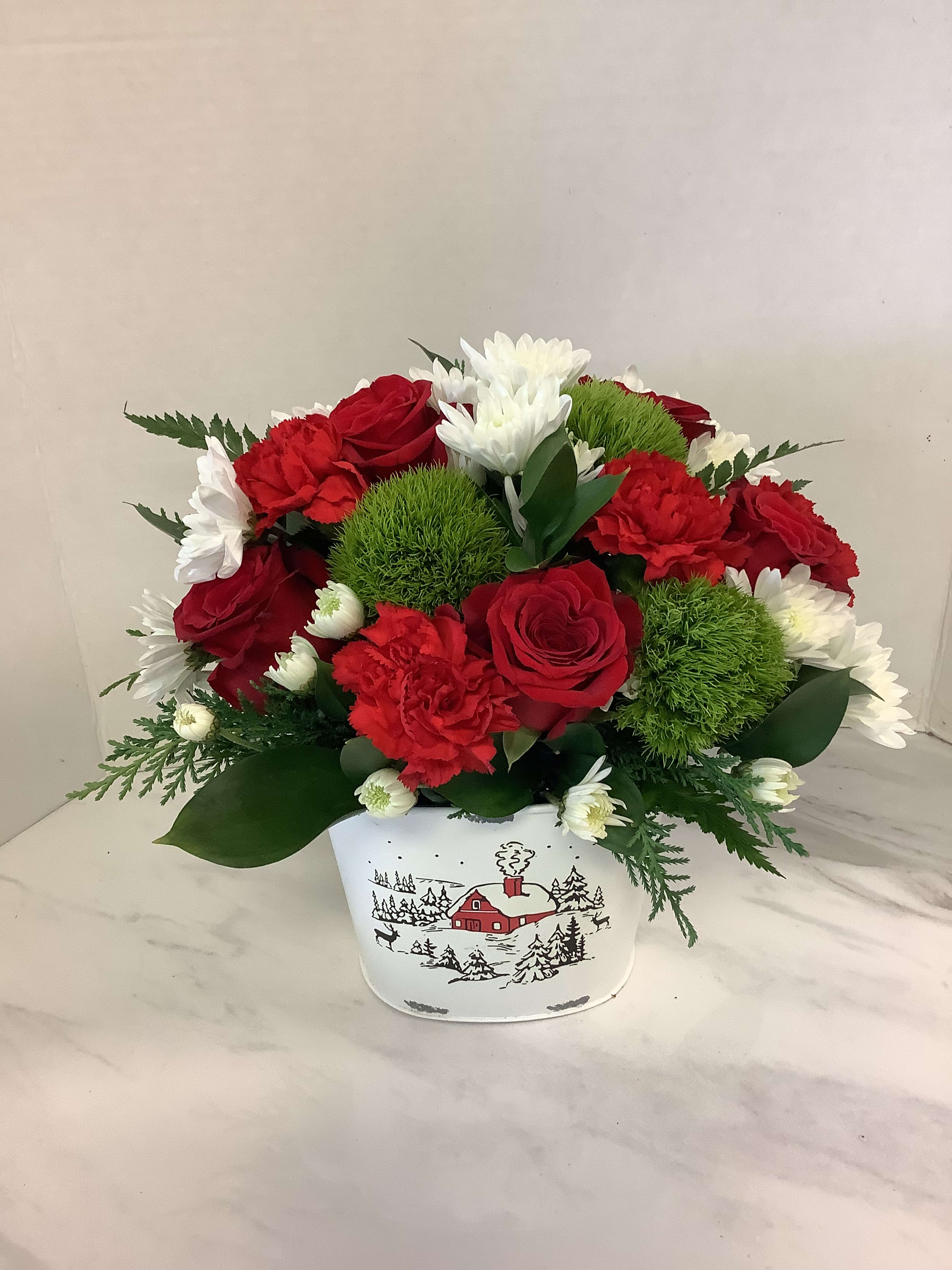 Red and white flower arrangement in a white holiday tin