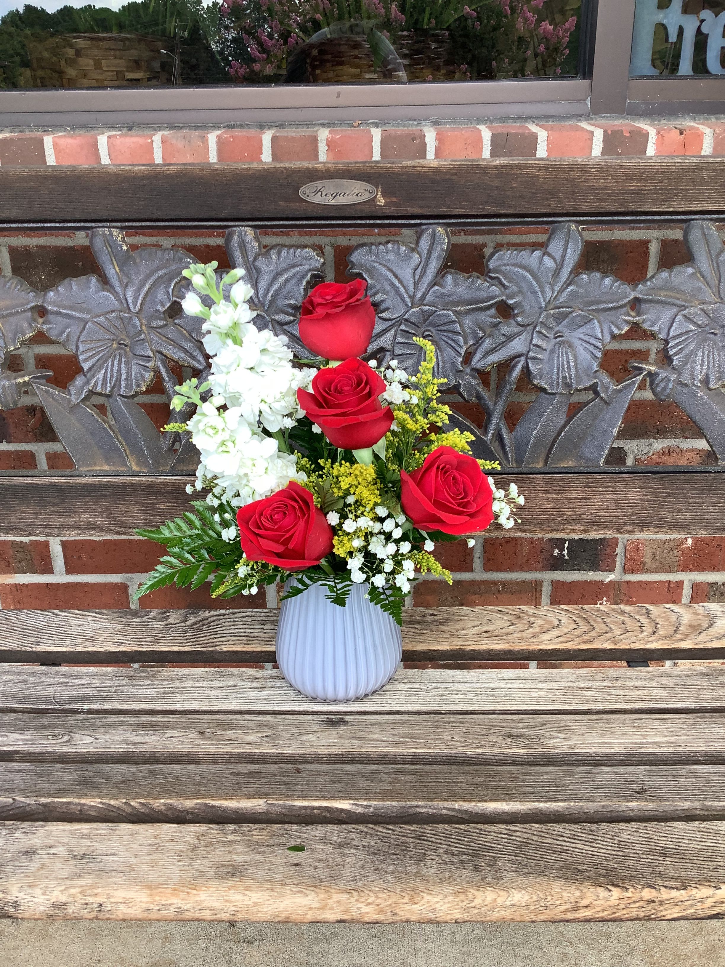 Red roses and white flowers in a white vase