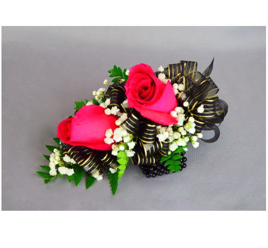 Two pink rose corsages with black ribbon and white filler flowers
