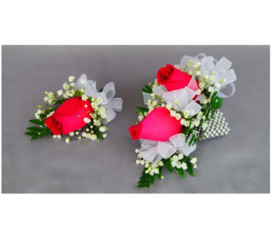 Two rose corsages with white ribbon and baby's breath