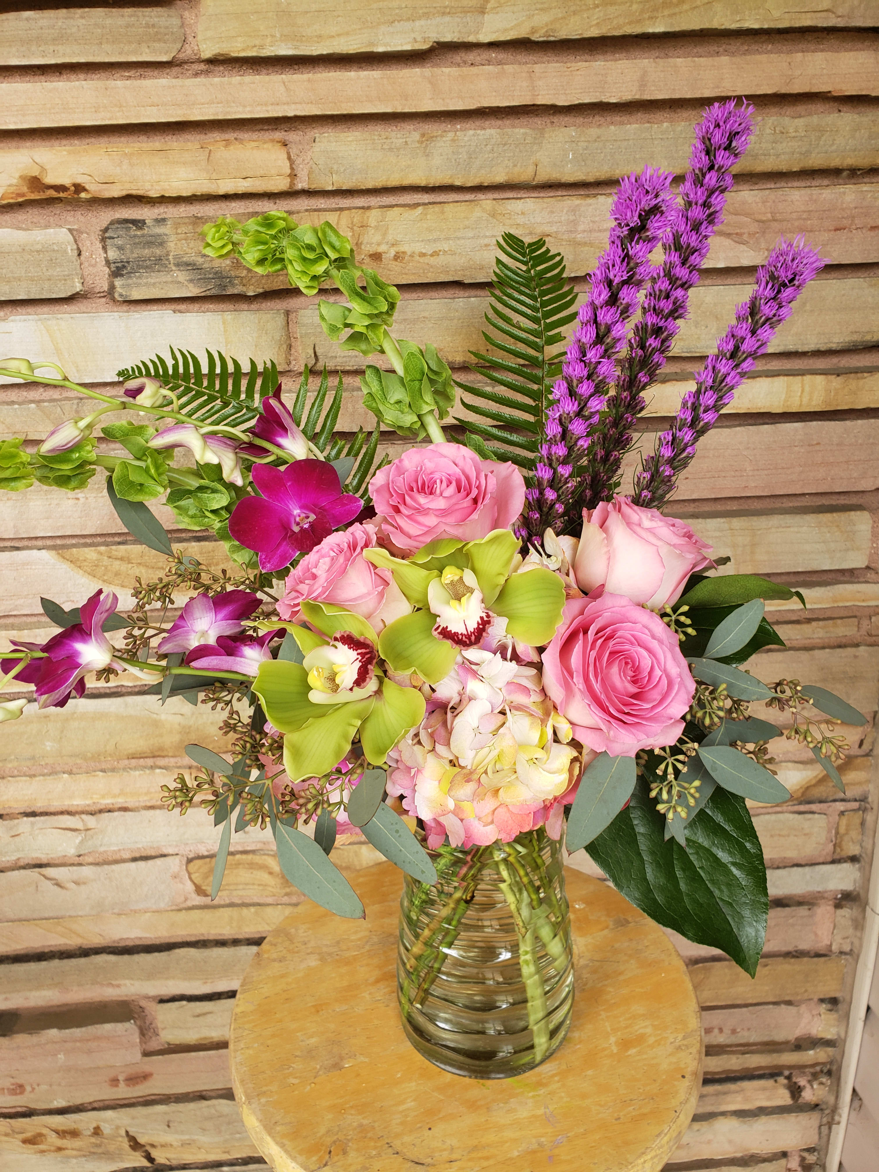 Pink roses and orchids in a glass vase