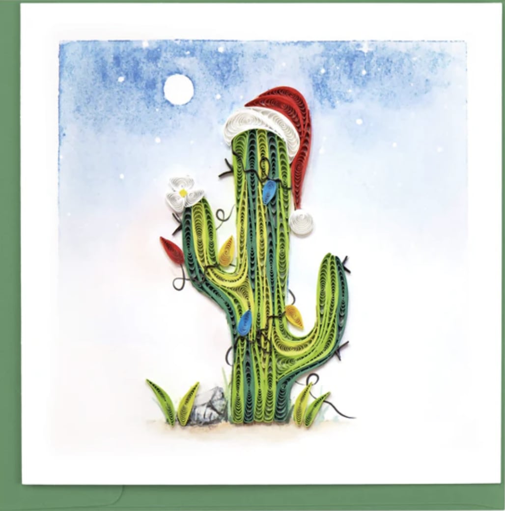 Quilled cactus artwork with a Santa hat on a snowy blue background