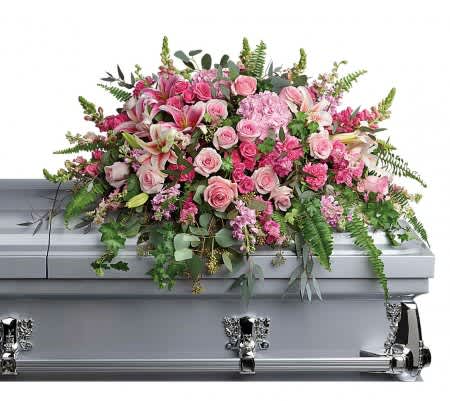 Pink rose and lily casket spray arranged on a silver casket