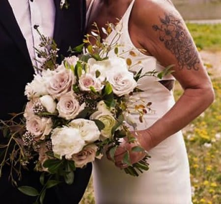 Bride holding a bouquet of pale roses and white flowers