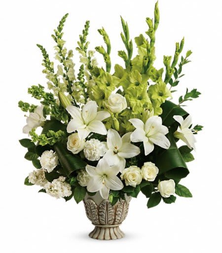 Tall white and green arrangement with lilies, roses, and carnations in an ornate ceramic urn.