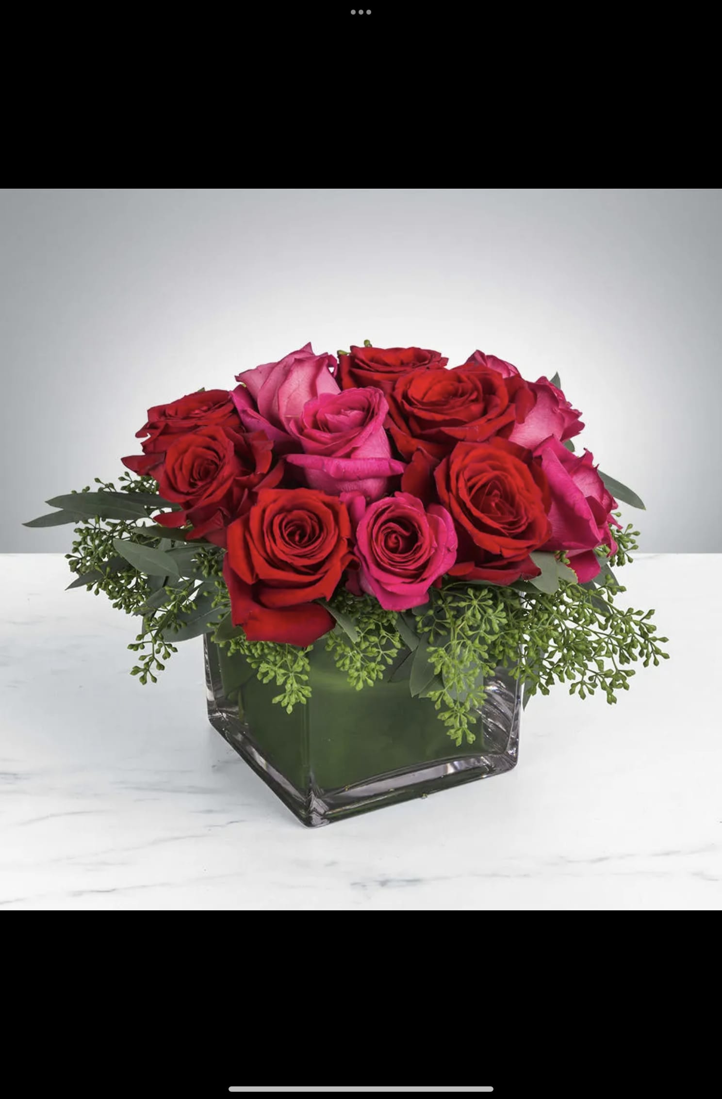 Red and pink roses arranged in a square glass vase