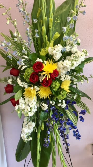 Tall mixed floral spray with red roses, yellow blooms, and white flowers